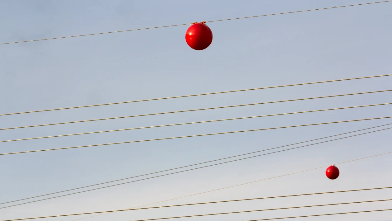Kleurrijke bollen aan elektriciteitskabels.