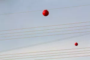 Kleurrijke bollen aan elektriciteitskabels.